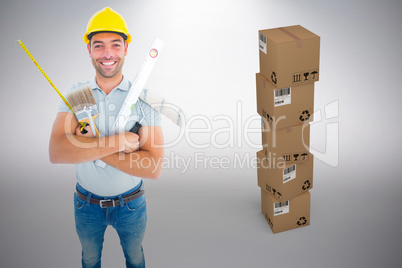 Composite image of portrait of happy manual worker holding various tools