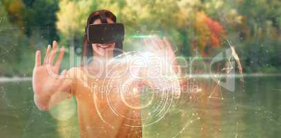Composite image of happy young woman gesturing while using virtual reality glasses