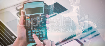 Composite image of hands of businesswoman using calculator