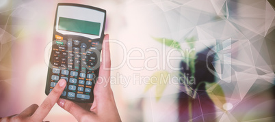 Composite image of hands of businesswoman using calculator