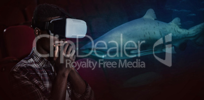 Composite image of man wearing virtual reality headset in theater