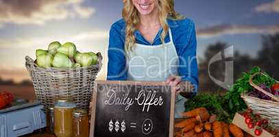 Composite image of happy woman with chalkboard and carrots