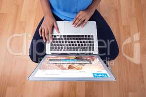 Composite image of mid section of female executive using laptop while sitting on wooden floor