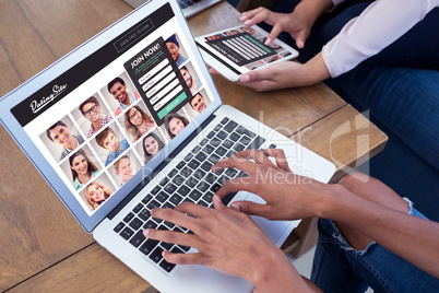 Composite image of executives using digital tablet and laptop at table