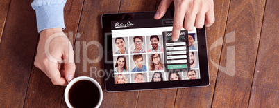 Composite image of man using digital tablet while having cup of coffee