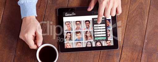 Composite image of man using digital tablet while having cup of coffee