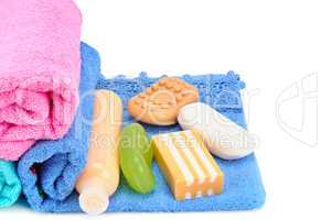 Cotton towels, cosmetic soap and shampoo isolated on white backg