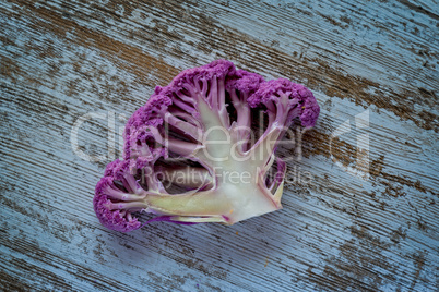 Purple color cauliflower vegetable on a gray table