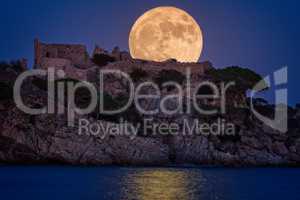 Full moon over the old castle in Costa Brava in a holiday village Fosca , Spain