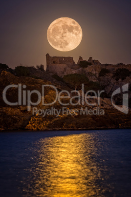 Full moon over the old castle in Costa Brava in a holiday village Fosca , Spain