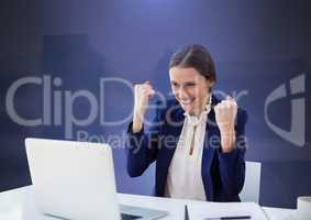 Businesswoman working on laptop celebrating success