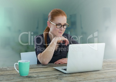 Businesswoman working on laptop with green background