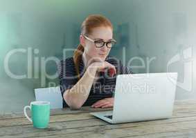 Businesswoman working on laptop with green background