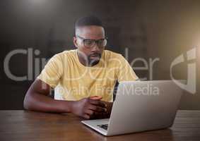 Businessman working on laptop with yellow flare in city
