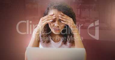 Woman working on laptop stressed holding head