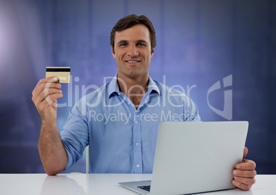 Businessman working on laptop with bank card and purple background