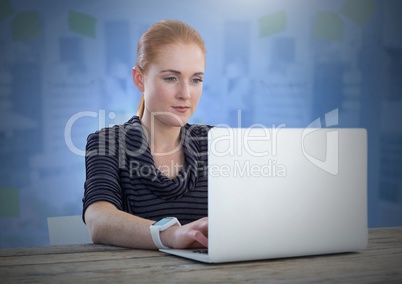 Businesswoman working on laptop with blue background