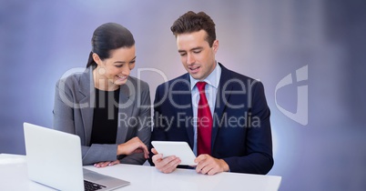 Business couple working on laptop with tablet