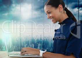 Businesswoman working on laptop with city background