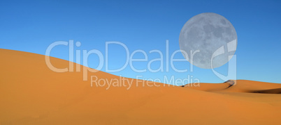 Beautiful sand dunes and blue sky and full moon