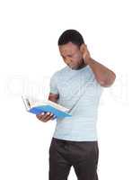 Puzzled African man looking at his book