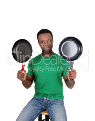 African American man holding up two freeing pan