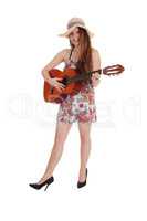 Woman standing in a dress with her guitar