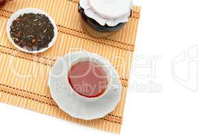 Cup of tea, jam jar and tea leaves isolated on white background.