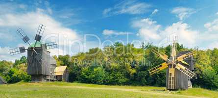 Old wooden windmill in a field and sky. Wide photo