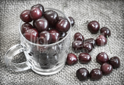 Glass Cup with cherries on the table.