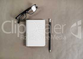 Notepad, glasses, pencil