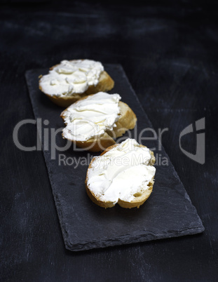 sandwiches with creamy white cheese on a black background