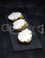 sandwiches with creamy white cheese on a black background