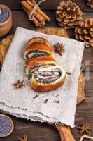 homemade roll with poppy seeds on a brown wooden board