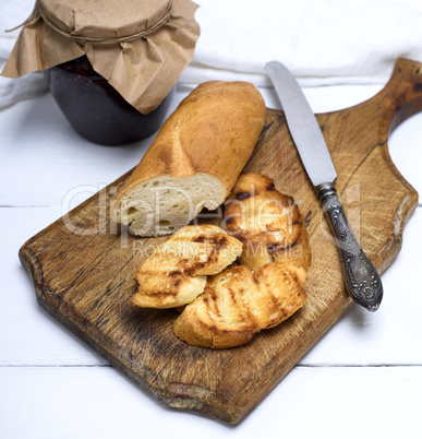 white bread on a brown wooden board and raspberry jam