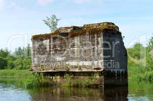 concrete Foundation of the destroyed bridge in the water, concrete support of the old blown-up bridge in the pond