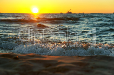 sunset on the sea, the waves beat against the breakwater, the sea at dawn, the ships on the horizon