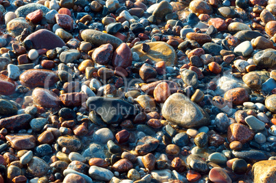 sea stones in the sand, the sea coast with stones and sand