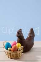 Easter chocolate chicken and colored eggs over a white table