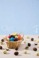 Easter chocolate eggs in a small basket with blue background