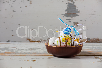 Colorful handmade easter eggs inside a wood bowl