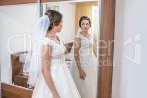 Bride in white dress looking in the mirror