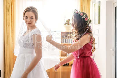 Bridesmaid and bride in white dress