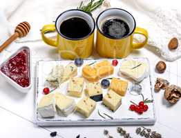 different pieces of cheese on a white wooden board