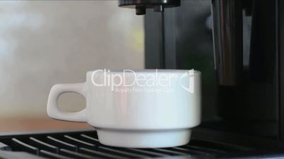 Close-up of coffee machine pouring espresso in small white cup