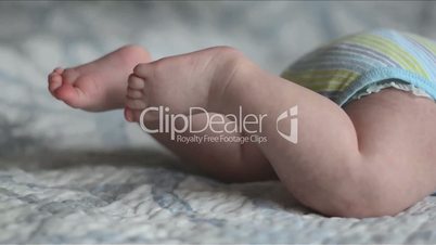 closeup of baby's feet trying to crawl on the bed