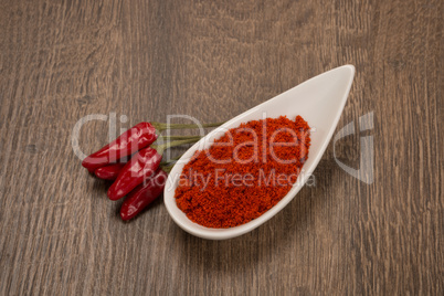 Ground and whole peppers on rustic wooden table
