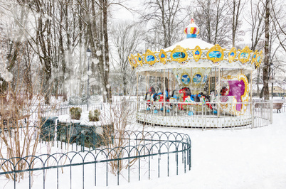Empty vintage carousel in the park on snowy winter day