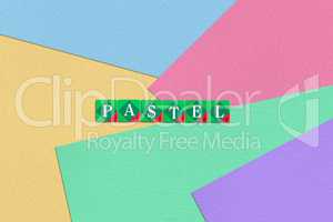 Scrabble letters spelling pastel on colorful paper background