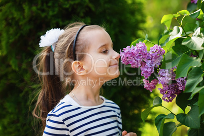 Girl smelling lilac flowers
